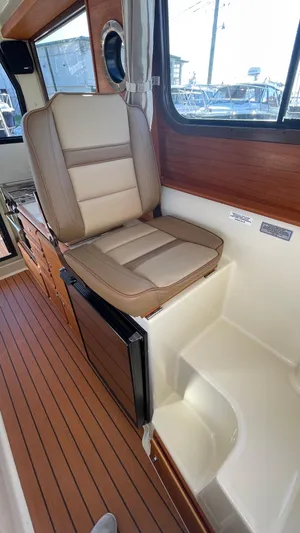  Yacht Photos Pics 2023 Ranger Tugs R-27 interior with cushioned seating and wood accents.