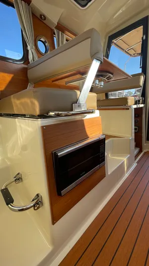  Yacht Photos Pics 2023 Ranger Tugs R-27 interior with wood accents and modern amenities.