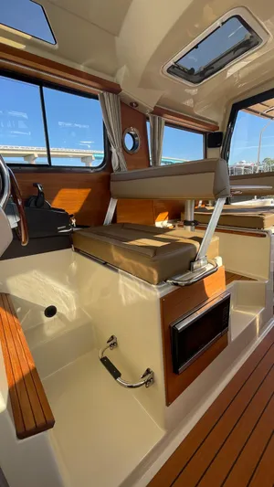  Yacht Photos Pics 2023 Ranger Tugs R-27 interior with wood accents and seating, showcasing modern design.