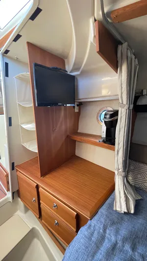  Yacht Photos Pics 2023 Ranger Tugs R-27 cabin interior with TV, drawers, and cozy bedding.