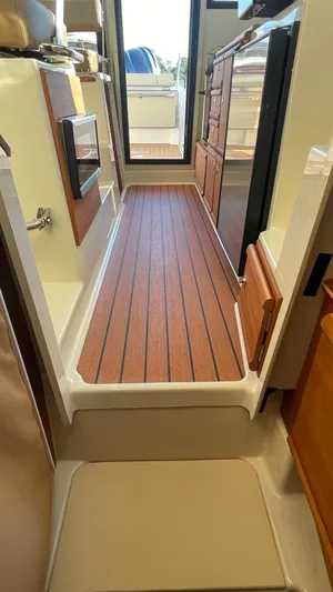  Yacht Photos Pics 2023 Ranger Tugs R-27 interior with wood flooring and modern cabinetry.