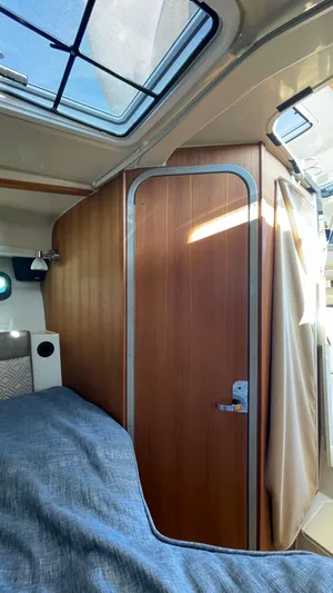  Yacht Photos Pics Interior of 2023 Ranger Tugs R-27, featuring a wooden door and cozy cabin space.
