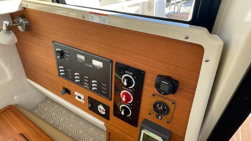  Yacht Photos Pics Control panel of 2023 Ranger Tugs R-27 boat with wood finish and various switches.