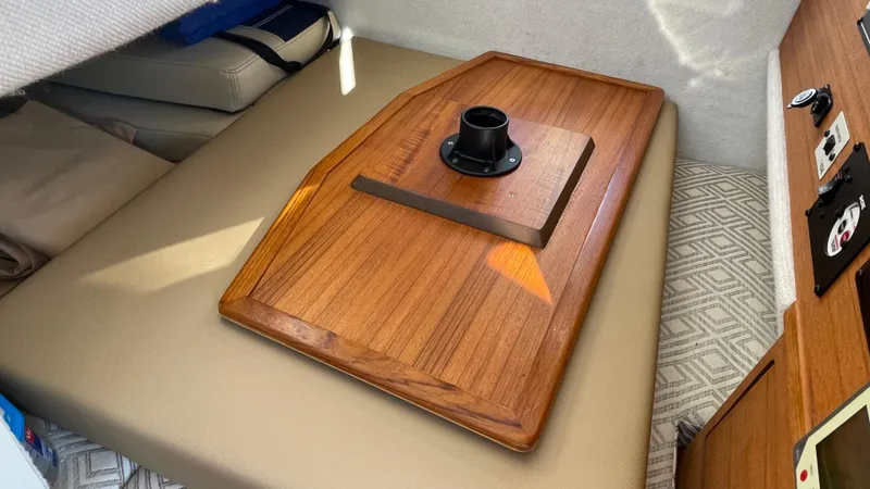  Yacht Photos Pics Interior of 2023 Ranger Tugs R-27 boat with wooden table and beige seating.