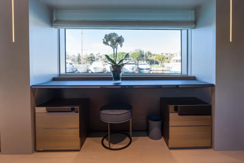M Forever Yacht Photos Pics Luxurious Navetta 33 yacht interior with desk, stool, and window view of marina.