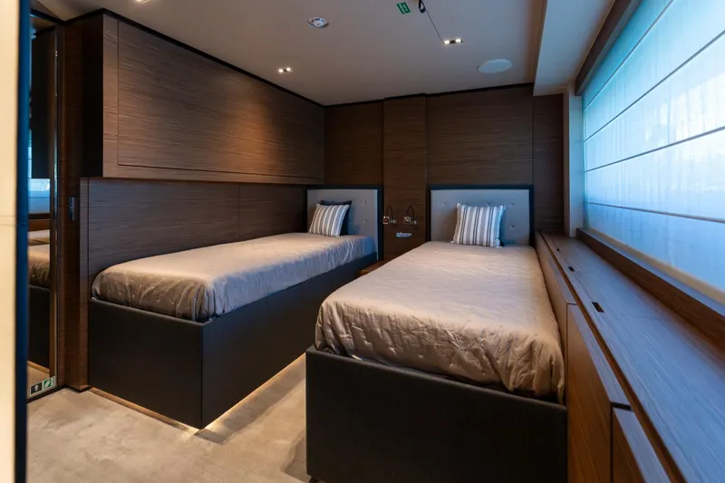 M Forever Yacht Photos Pics Luxurious twin bedroom on 2021 Custom Line Navetta 33 yacht, featuring modern wood paneling.
