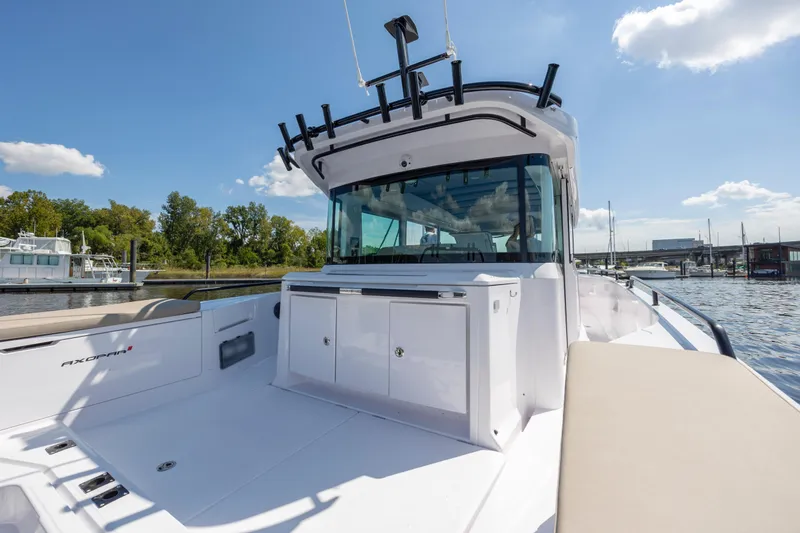 Yacht Photos Pics 2024 Axopar 37 XC boat on water, showcasing sleek design and spacious deck.