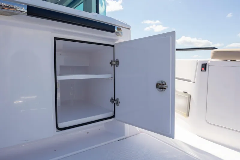 Yacht Photos Pics Open storage compartment on 2024 Axopar 37 XC boat, showcasing interior shelving.