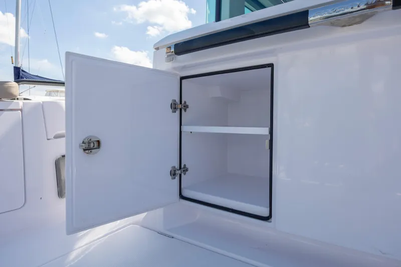  Yacht Photos Pics Open storage compartment on 2024 Axopar 37 XC boat, showcasing interior shelving.
