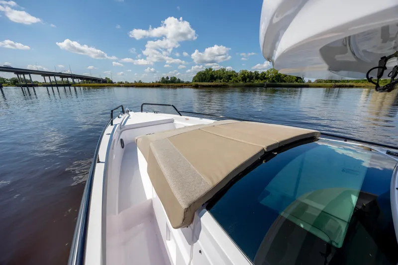  Yacht Photos Pics 2024 Axopar 37 XC boat on calm water, featuring a sunbed and scenic view.