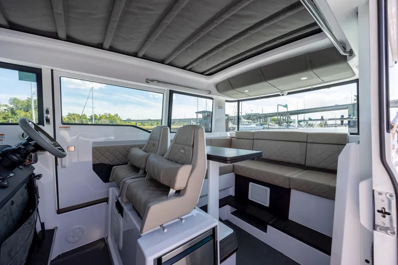  Yacht Photos Pics 2024 Axopar 37 XC interior with seating, table, and helm station.