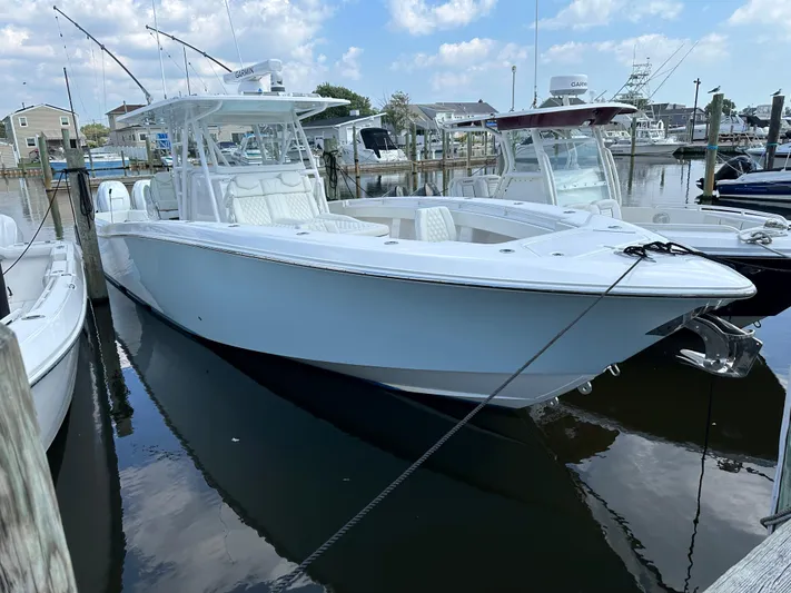  Yacht Photos Pics 2021 Invincible 390 Open CC boat docked in a marina under a partly cloudy sky.