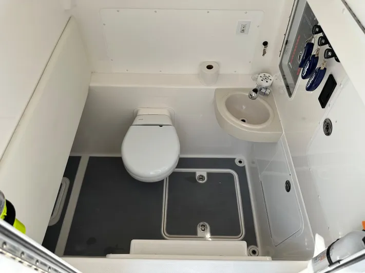  Yacht Photos Pics 2021 Invincible 390 Open CC boat bathroom with toilet, sink, and control panel.