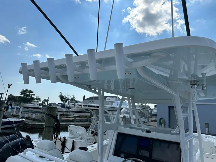  Yacht Photos Pics 2021 Invincible 390 Open CC boat with rod holders and navigation equipment at a marina.