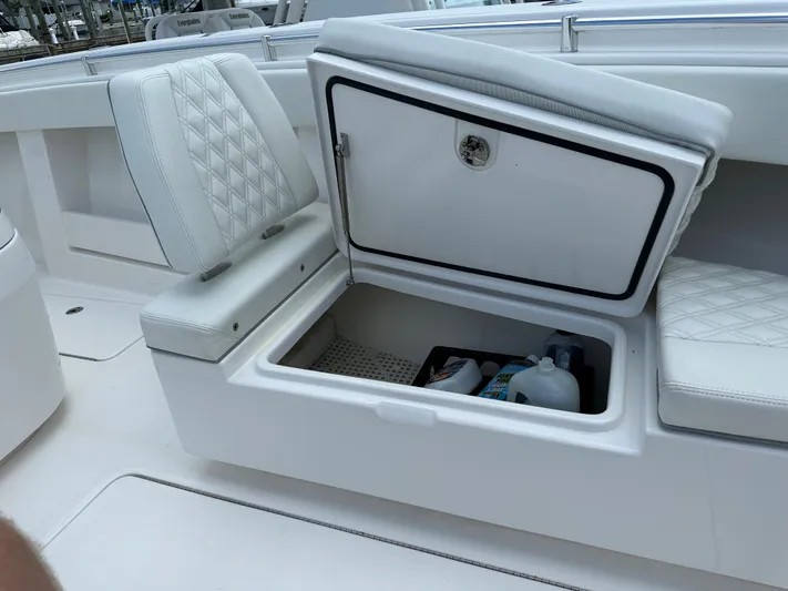  Yacht Photos Pics 2021 Invincible 390 Open CC boat with open storage compartment and white cushioned seating.