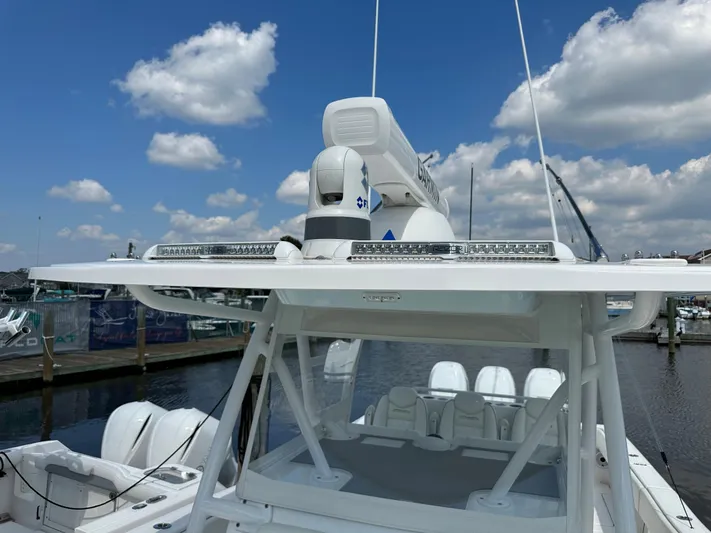  Yacht Photos Pics 2021 Invincible 390 Open CC boat with advanced radar system, docked under a blue sky.