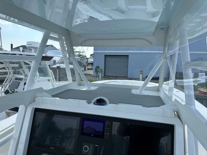  Yacht Photos Pics 2021 Invincible 390 Open CC boat interior with navigation console and clear canopy.