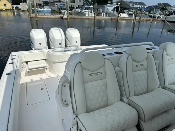  Yacht Photos Pics 2021 Invincible 390 Open CC boat with triple engines and luxurious seating in a marina setting.