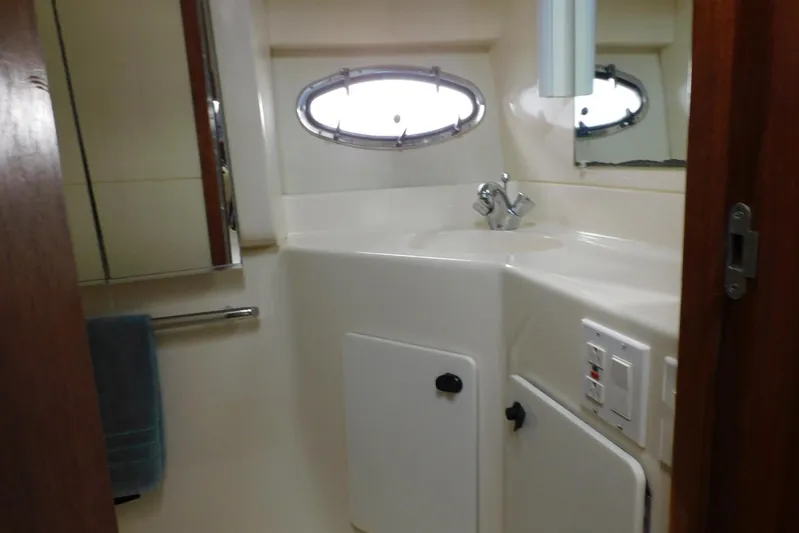 Squall Line Yacht Photos Pics Bathroom interior of 1995 Tiara Yachts 3500 Express with sink and porthole window.