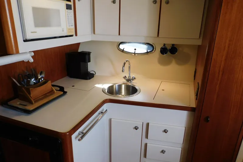 Squall Line Yacht Photos Pics 1995 Tiara Yachts 3500 Express kitchen with sink, microwave, and coffee maker.