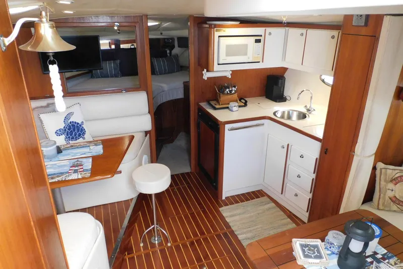 Squall Line Yacht Photos Pics Interior of 1995 Tiara Yachts 3500 Express, featuring cozy dining area and compact kitchen.