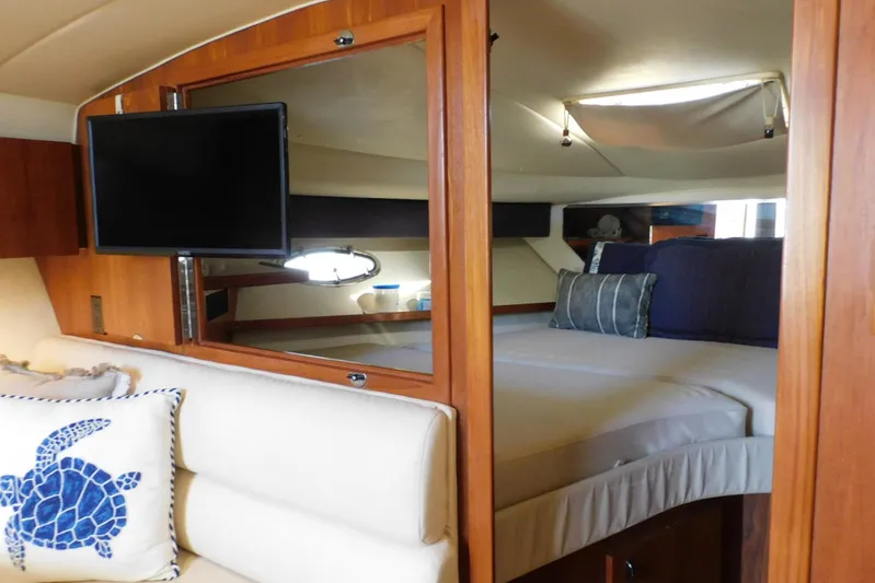 Squall Line Yacht Photos Pics 1995 Tiara Yachts 3500 Express interior with bed, TV, and nautical decor.