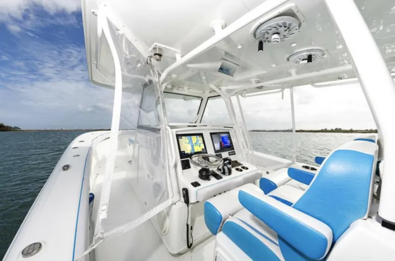  Yacht Photos Pics 2018 Yellowfin 39 boat interior with blue and white seating, navigation screens, and ocean view.