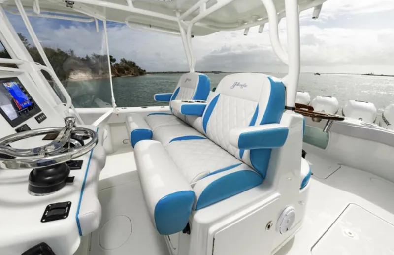 Yacht Photos Pics 2018 Yellowfin 39 boat interior with blue and white seating, steering wheel, and ocean view.