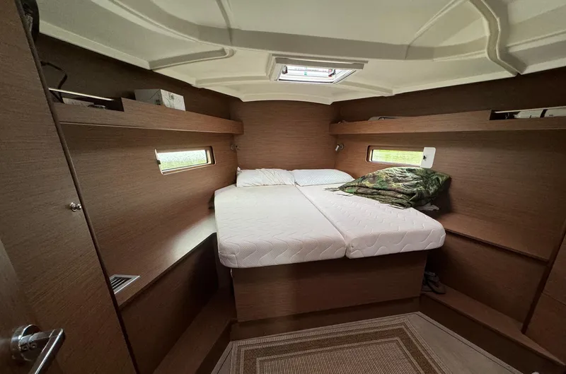 Odyssey Yacht Photos Pics Cozy cabin interior of 2021 Beneteau Oceanis 40.1 yacht with double bed and wooden finish.