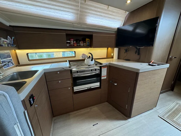 Odyssey Yacht Photos Pics Modern kitchen in 2021 Beneteau Oceanis 40.1 yacht with stove, sink, and TV.
