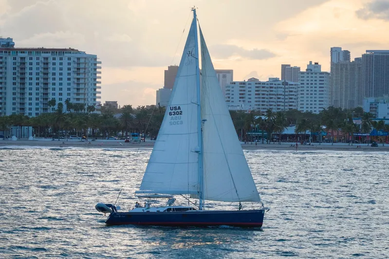 Blue Star Yacht Photos Pics Sailing yacht Hylas 63, 2013 model, cruising near a city skyline at sunset.