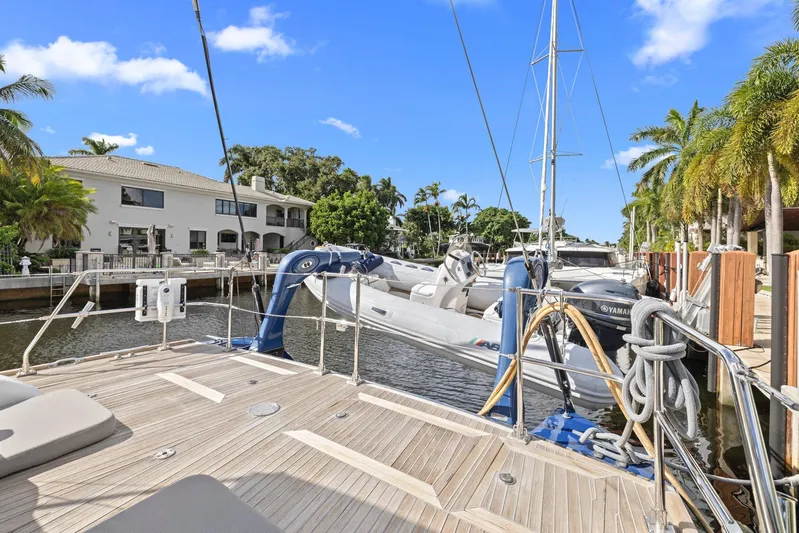 Blue Star Yacht Photos Pics Deck view of a 2013 Hylas 63 yacht docked by waterfront homes and palm trees.