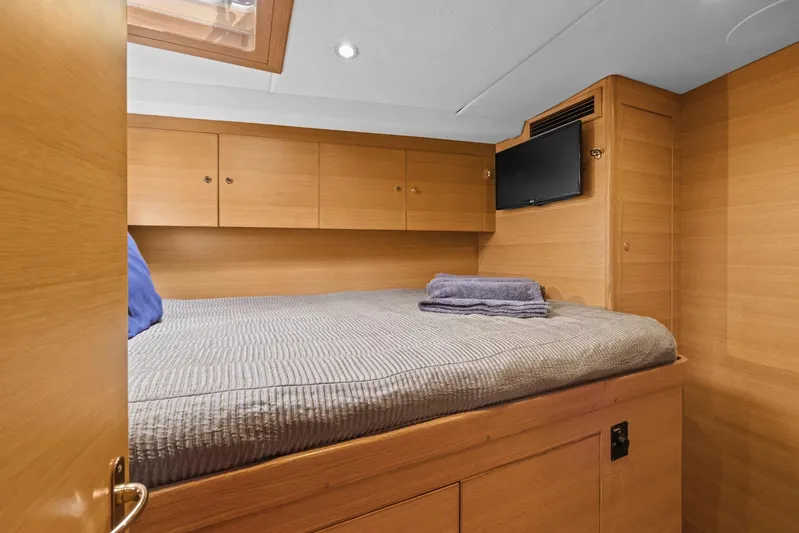 Blue Star Yacht Photos Pics Cozy cabin interior of 2013 Hylas 63 yacht with bed, TV, and wooden cabinetry.