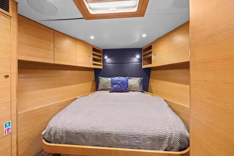 Blue Star Yacht Photos Pics Luxurious cabin interior of a 2013 Hylas 63 yacht with cozy bedding and wooden cabinetry.