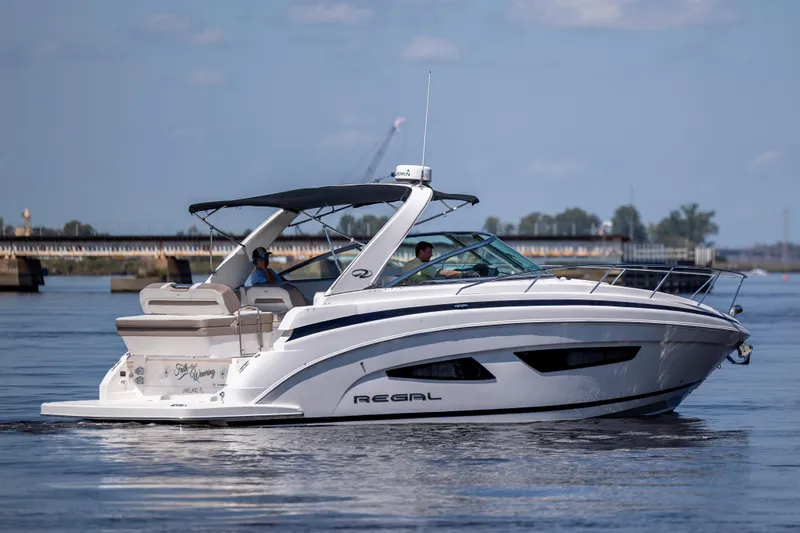  Yacht Photos Pics 2017 Regal 32 Express boat cruising on a calm river with bridge in background.