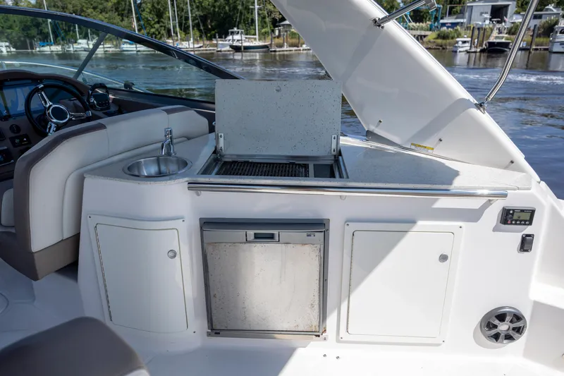  Yacht Photos Pics 2017 Regal 32 Express yacht interior with kitchenette and sink, docked by the water.