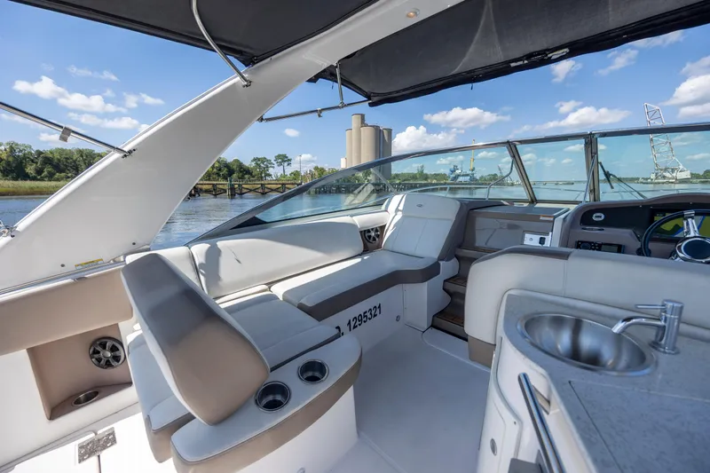  Yacht Photos Pics 2017 Regal 32 Express boat interior with seating, sink, and steering wheel, docked by a river.