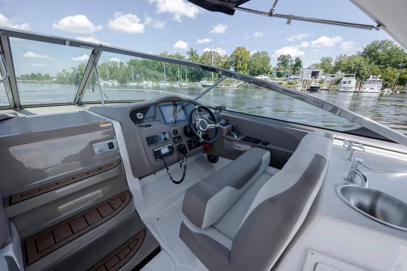  Yacht Photos Pics 2017 Regal 32 Express boat cockpit with steering wheel, dashboard, and water view.