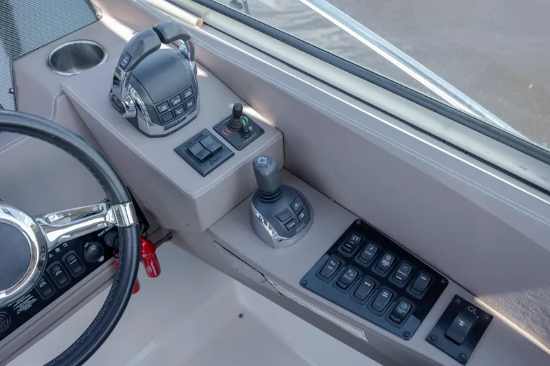  Yacht Photos Pics Control panel of a 2017 Regal 32 Express boat with steering wheel and switches.