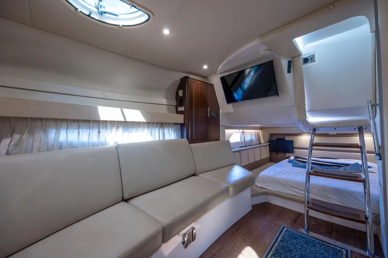  Yacht Photos Pics Luxurious interior of a 2017 Regal 32 Express yacht with sofa, bed, and TV.
