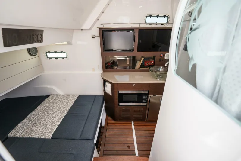 Mad Hatter Yacht Photos Pics 2019 Everglades 435 Center Console cabin with bed, kitchenette, and TV.