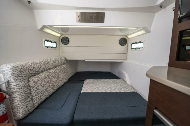 Mad Hatter Yacht Photos Pics 2019 Everglades 435 Center Console cabin interior with cushioned seating and small windows.