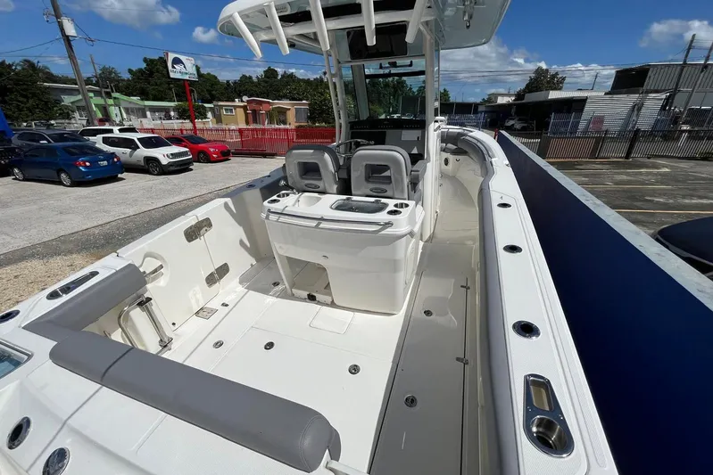 Yacht Photos Pics 2024 Boston Whaler 280 Outrage boat interior, featuring seating and console, parked outdoors.