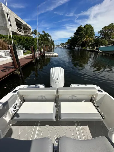  Yacht Photos Pics 2023 Everglades 235 boat docked in a scenic canal with lush greenery.
