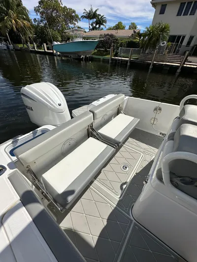  Yacht Photos Pics 2023 Everglades 235 boat with foldable seating, docked by a waterfront home.