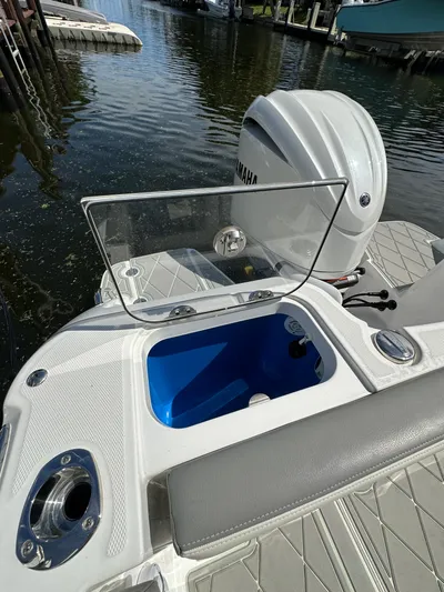  Yacht Photos Pics 2023 Everglades 235 boat with open storage compartment and Yamaha outboard motor.