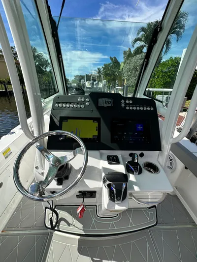  Yacht Photos Pics 2023 Everglades 235 boat cockpit with modern navigation system and steering wheel.