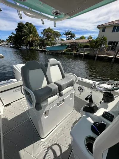  Yacht Photos Pics 2023 Everglades 235 boat interior with dual seats, steering console, and waterfront view.