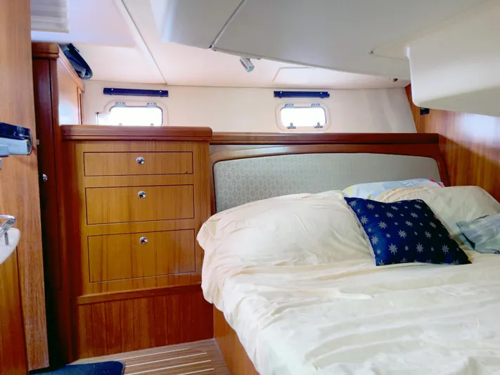 Wild Card Yacht Photos Pics Cozy cabin interior of 2005 Hunter 38 sailboat with wooden cabinetry and comfortable bedding.