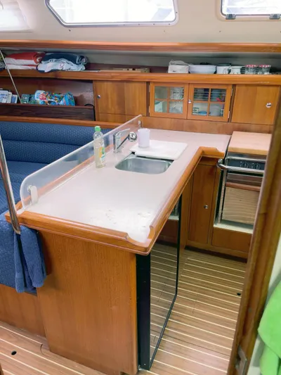Wild Card Yacht Photos Pics Interior of 2005 Hunter 38 sailboat kitchen with wooden cabinetry and compact design.